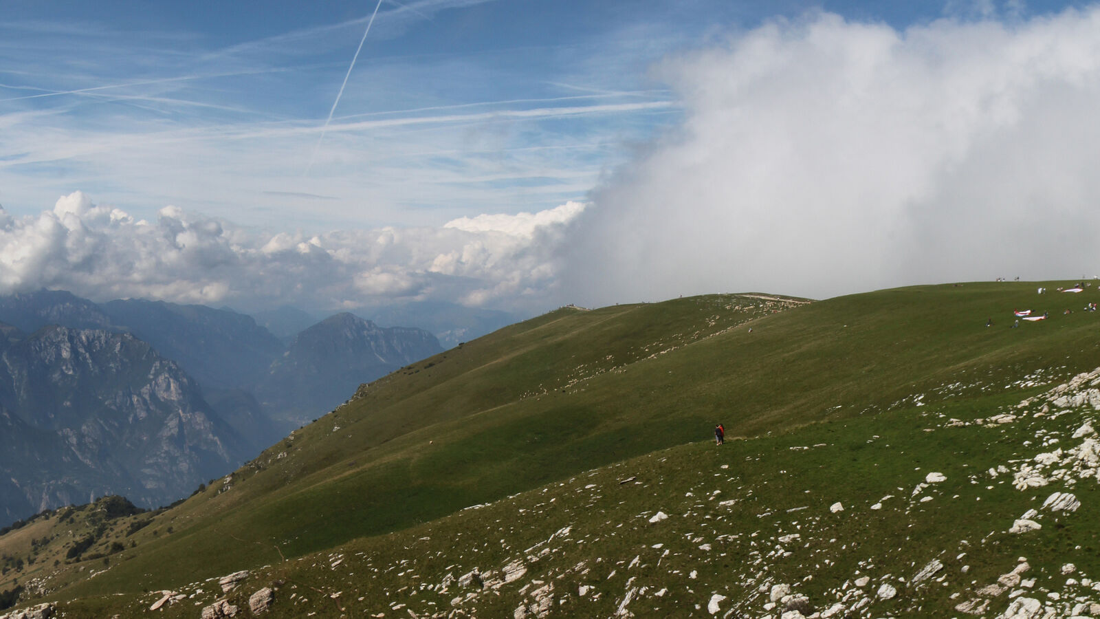 Bergrücken des Monte Baldo mit Wandergelände und Wolken über dem Gardasee
