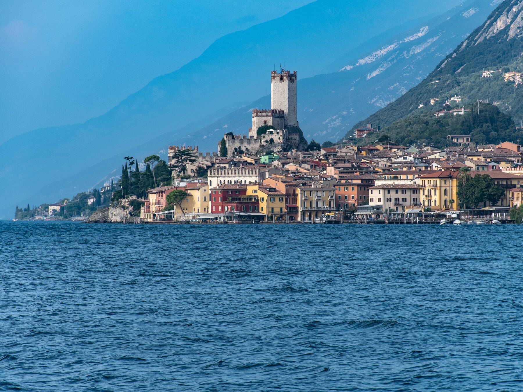 Der Uferort Malcesine am Gardasee mit dem Turm der Scaliger-Burg über bunten Häusern